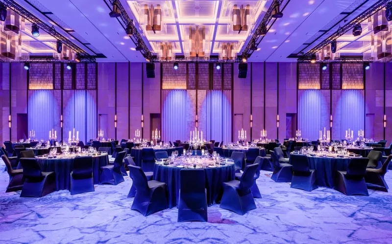 A large banquet hall with a gala setup and blue lighting at the Grand Hyatt Singapore.
