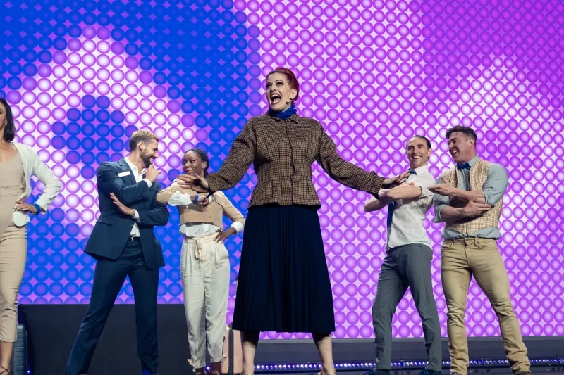 A group of six people on stage, in front of a purple background, at Cvent CONNECT 2023.