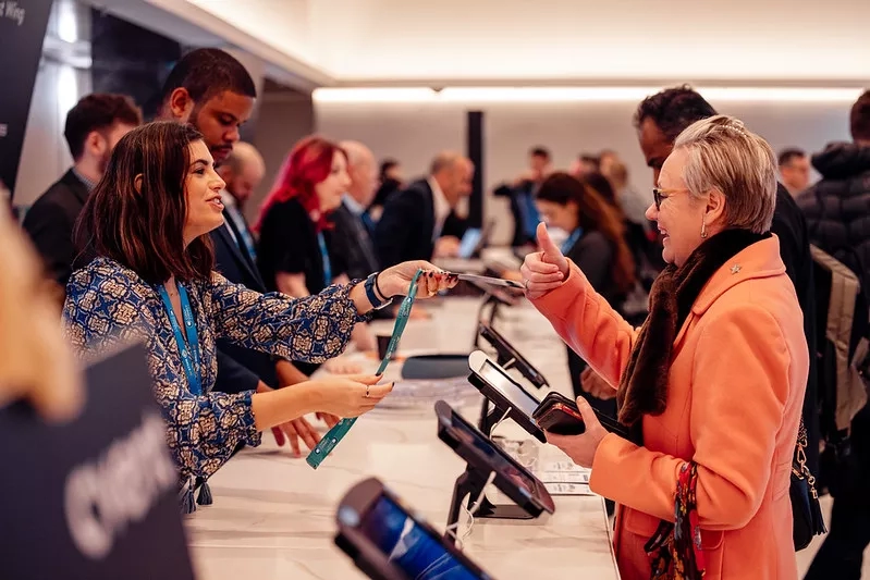 A woman giving a thumbs up as she registers for an event at the Clyde Auditorium in Glasgow.