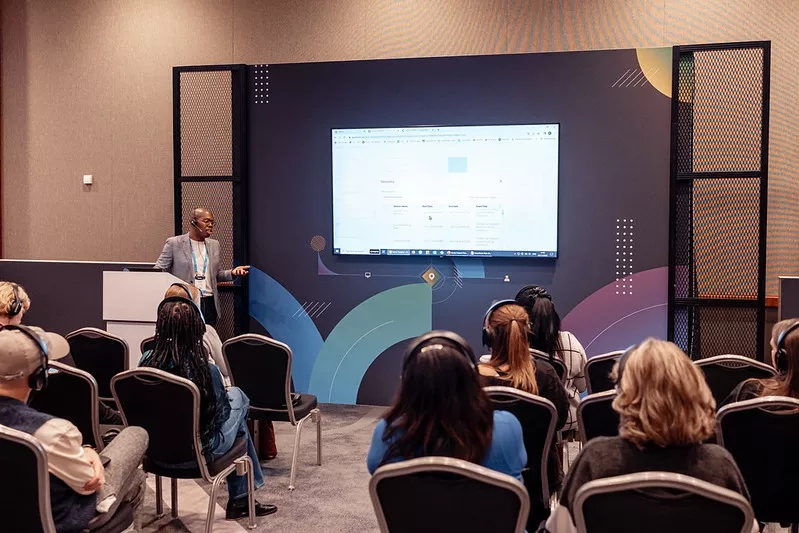 A woman is giving a presentation in front of a group of people.