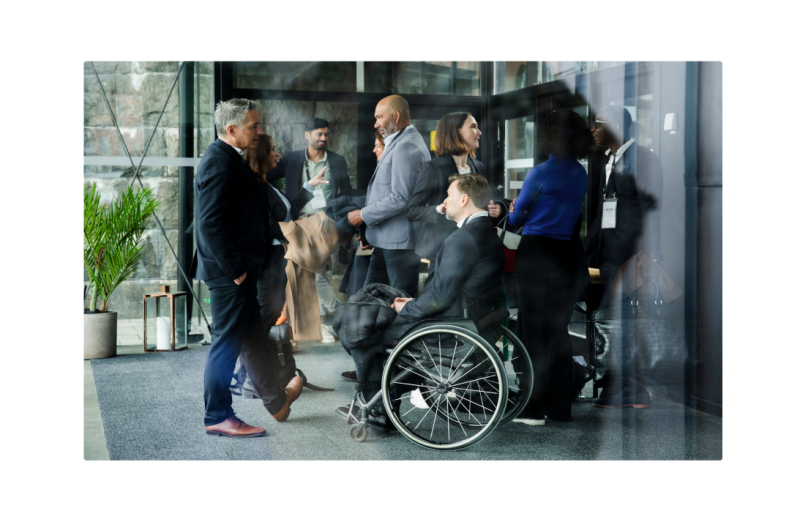 Group of people including man in wheelchair networking at an event