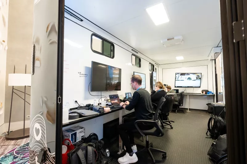 A man works on a laptop at a desk inside the Cvent CONNECT technology suite.