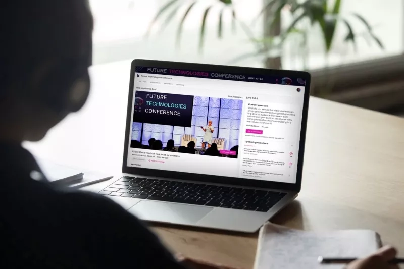 A person is attending the Future Technologies Conference on their laptop at a desk.
