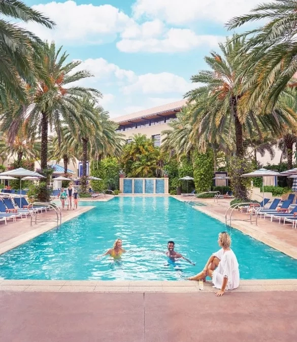 A group of people are enjoying a beautiful pool at the JW Marriott Marco Island Beach Resort.