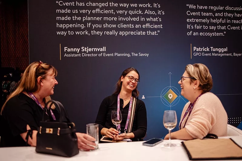 Three women sitting at happy hour drinking and laughing