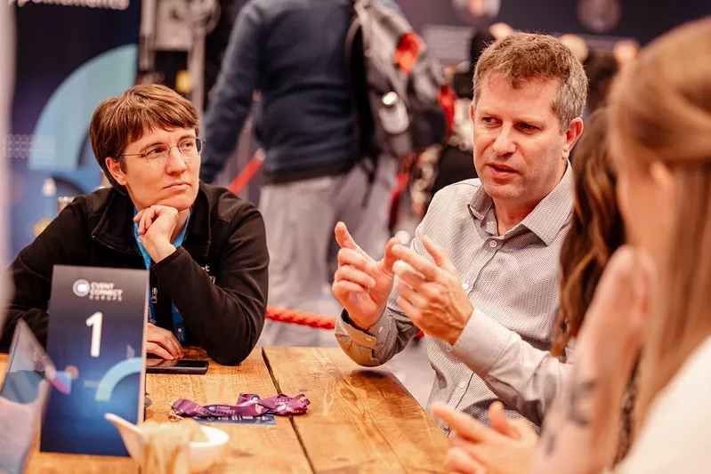 Three people in a meeting discussing market trends