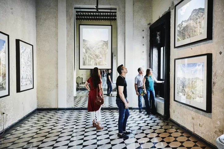 Group of people viewing art on display at The Old Bishop’s Palace in Havana, Cuba.