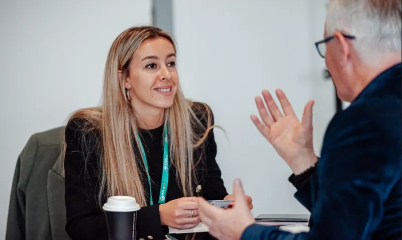 A woman and a man are having a meeting with a cup of coffee on the table.
