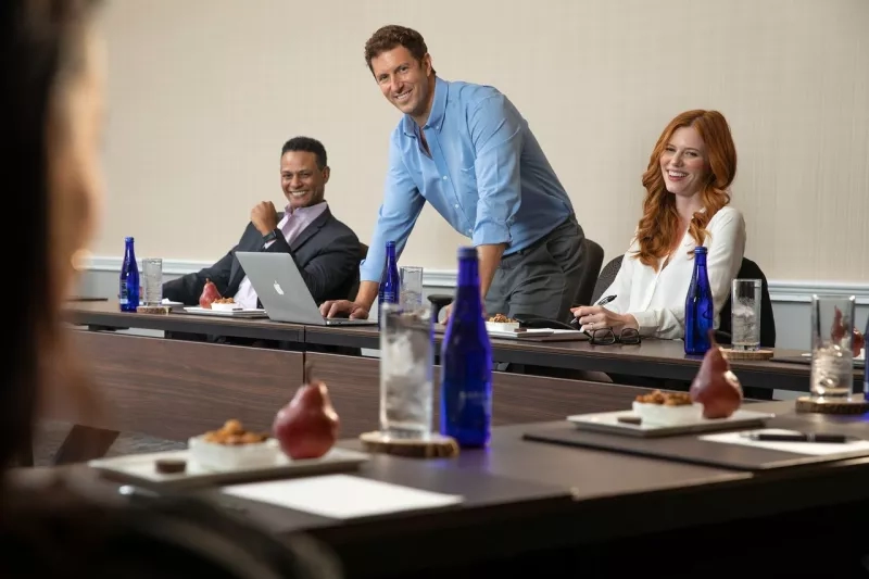 Three models at a meeting table during a meeting with laptops, water, and snacks at The Westin Atlanta Perimeter North.