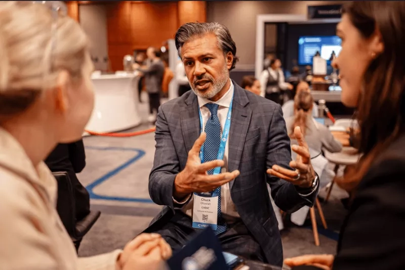 Chuck Ghoorah speaking to two women at a conference about event goals.
