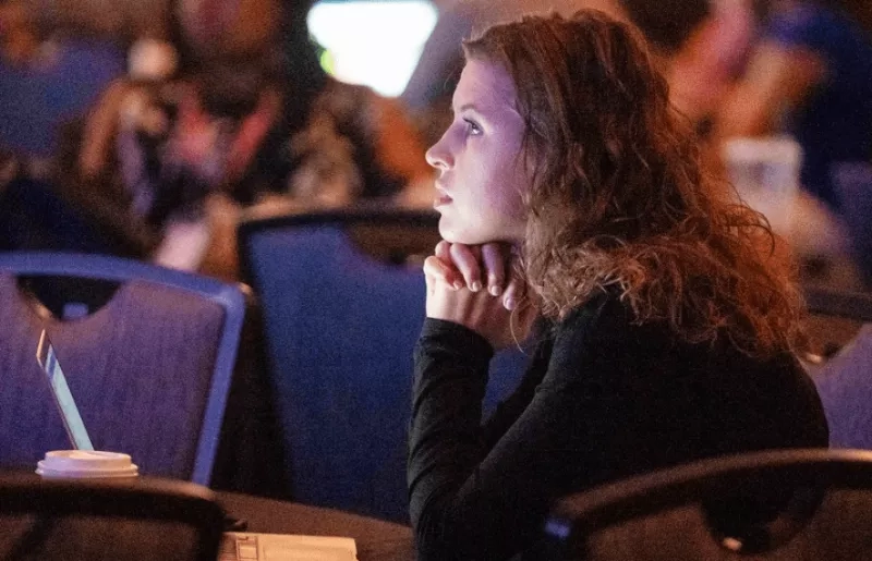 A woman with a laptop in a meeting room at the University of Canberra.