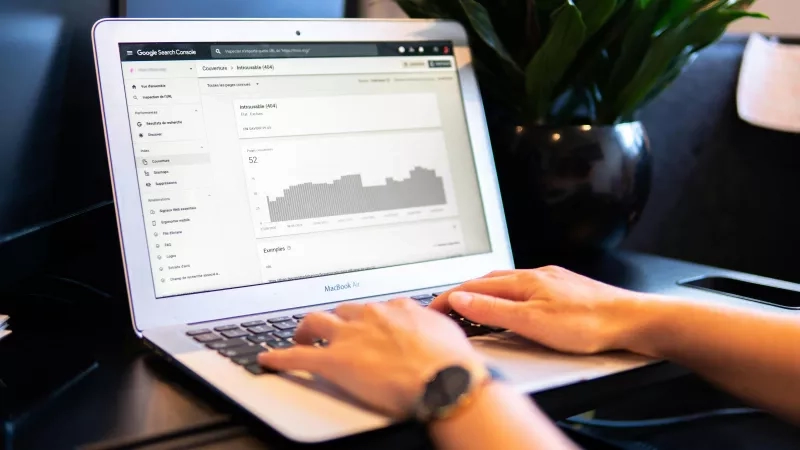 Close up of person typing on laptop with Google Search Console page open on the screen.