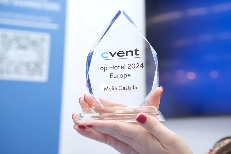 A hand holding a crystal trophy with the text "Top Hotel 2024 Europe Meliá Castilla" engraved on it.