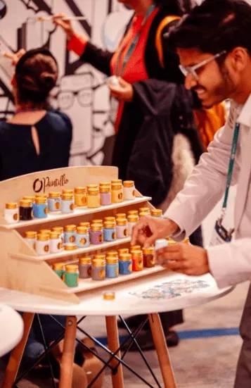 A person standing in front of a desk, and he is holding a box in his hand.
