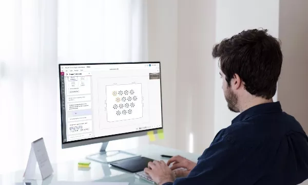 Man using Excel for landscaping design with a tablet and a pen on a desk in a bright room.