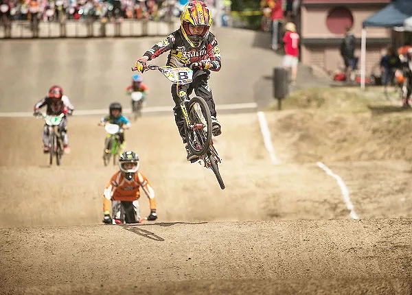 BMX bike racers, jumping in the air, and racing on the dirt track in North SeaTac Park.