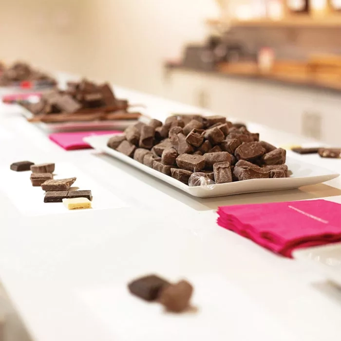 A long table with a white plate filled with chocolates and some napkins on it in Seattle Chocolates.