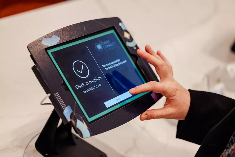 Person checking in at the event check-in kiosk with their name on the screen.