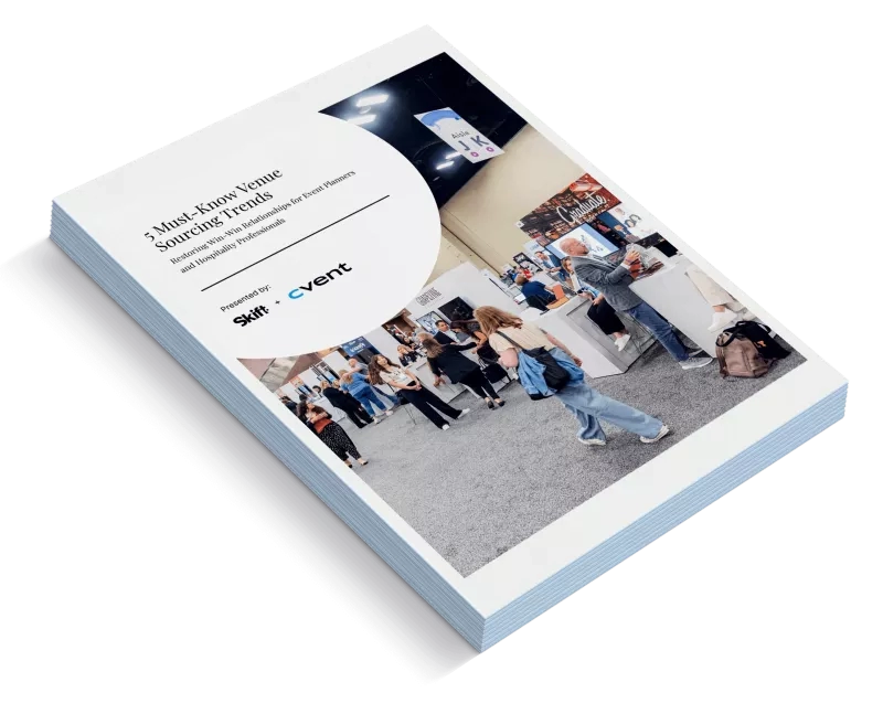 A stack of Cvent brochures with a Skift logo on top and people in the background.