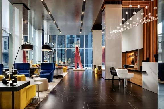 The interior of the lobby of the Mandarin Oriental Boston with glass walls and furniture.