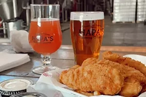 Two glasses of Hepa's beer, french fries, and containers on a table in Hepa's Brewing Company.