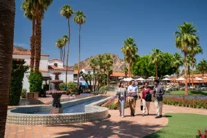 Four people walking towards the fountain at La Quinta Resort & Club, a Waldorf Astoria Resort.