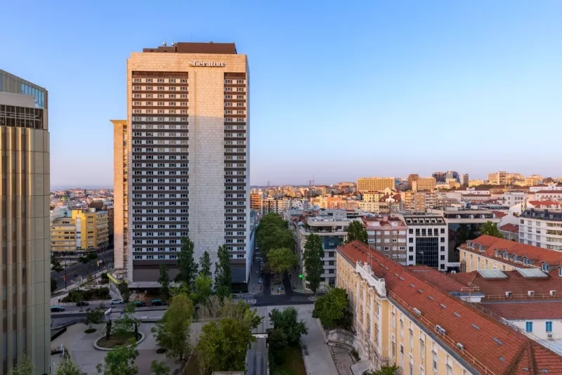 Exterior view of the Sheraton Lisboa Hotel & Spa featuring modern architecture and urban landscaping.