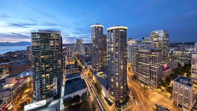 Night view of Westin Seattle hotel with cityscape and lights on the buildings.