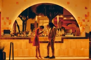 A couple stands at a bar in the Tropica Bar & Lounge, with an arch behind them.