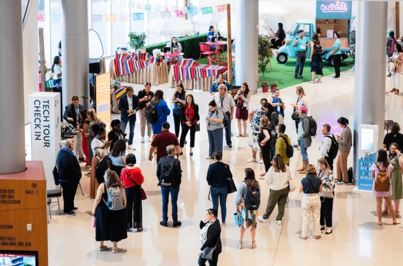 People in an event lobby with event chatbot on the right side of the image.