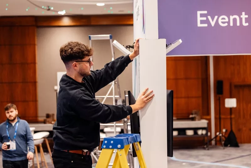 A man is setting up an event logistics setup for Cvent CONNECT Europe 2024.