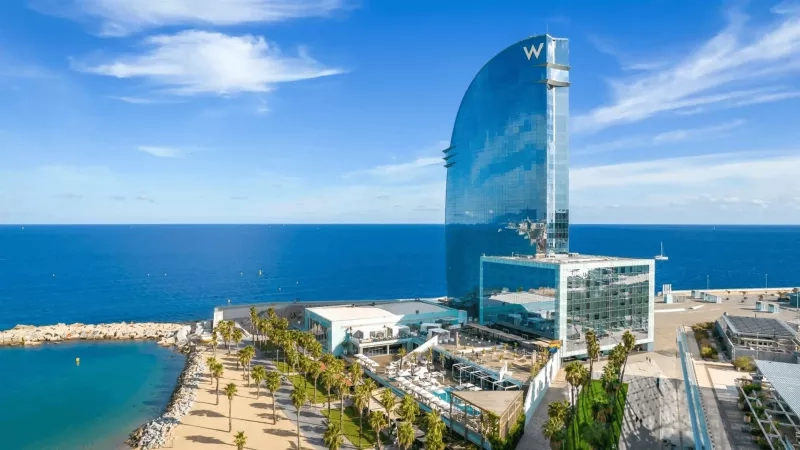 W Barcelona Hotel in Spain, overlooking the sea, with modern architecture, and lush landscaping.