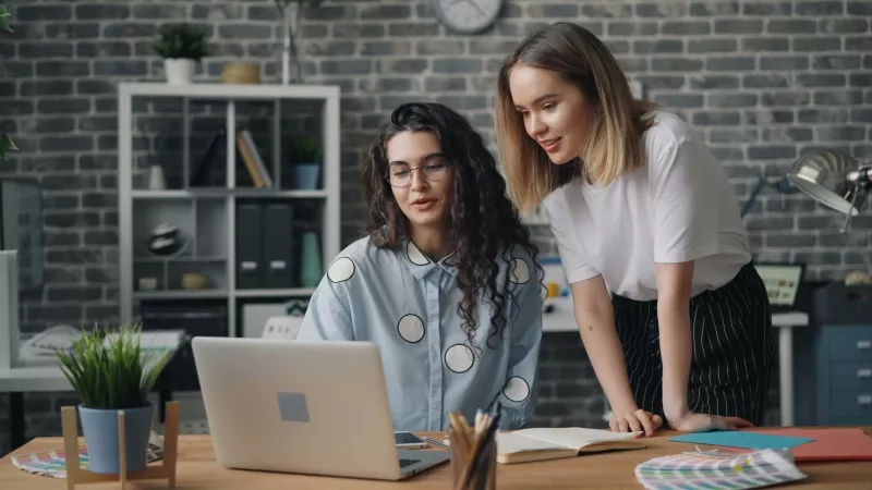Two women looking at data on a computer