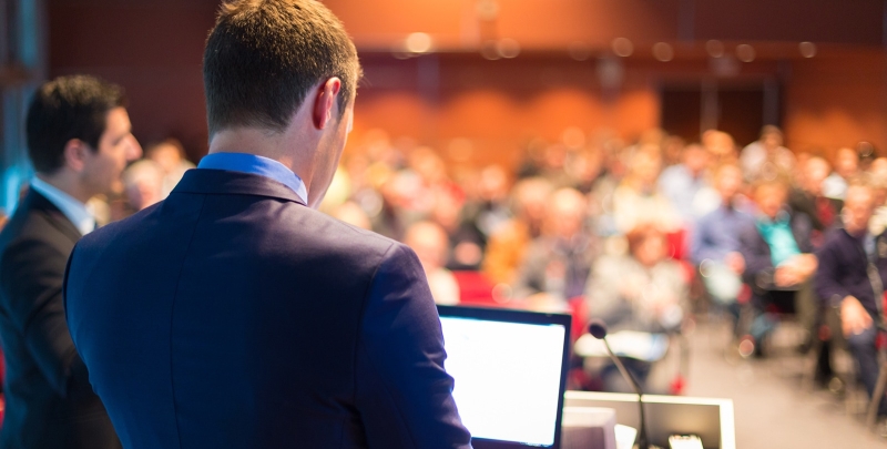 Man giving a presentation to a group of business people at a conference or seminar