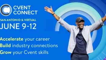 A man in cap and glasses is raising his hands in front of a blue background.