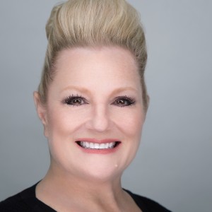 A headshot of Kathy Wagner, an adult woman with blonde hair and a black top.