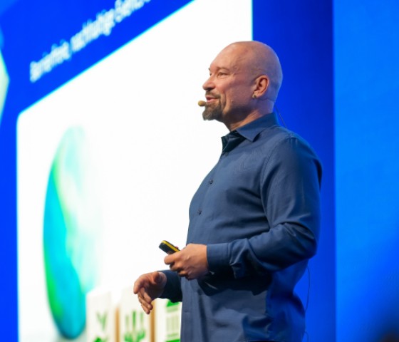 Markus Laibacher speaks at a Cvent Accelerate event in front of a screen that says AC.