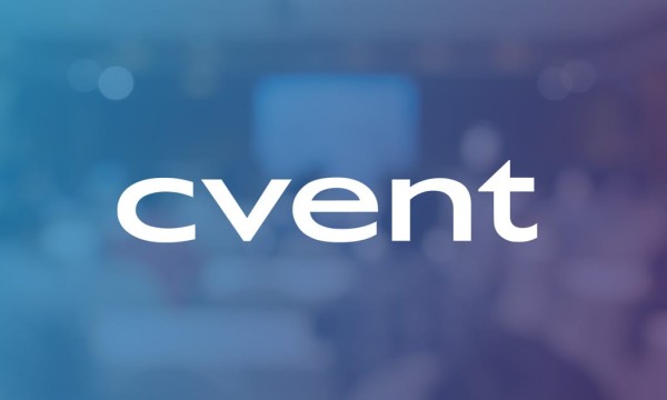 Cvent logo in front of a blurred conference room with people and a presentation screen.