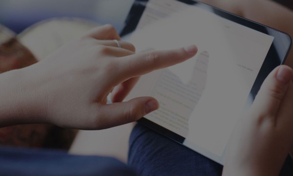 A woman is looking at an employee satisfaction survey on a tablet.