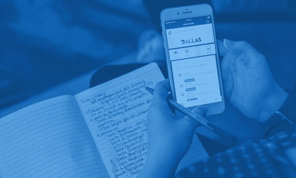 Person holding a smartphone with the Allas app open and a notebook with notes written in it.