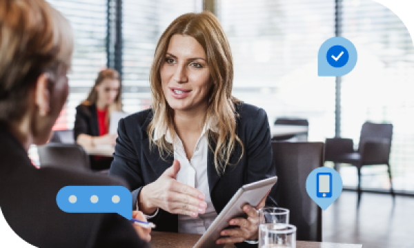 Businesswoman giving presentation to client with icons for check mark, cell phone, and speech bubble.