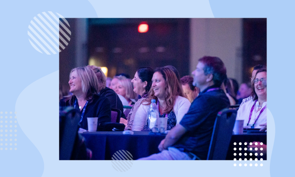 A group of people are sitting around a table at an event with bottles and cups on it.
