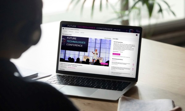 A person is attending the Future Technologies Conference on their laptop at a desk.