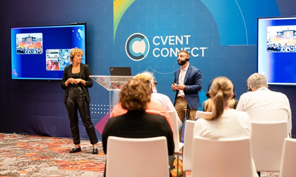 Man and woman giving a presentation to an audience in front of a Cvent Connect sign.