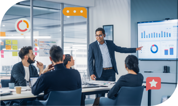 An executive gives a presentation in a meeting room with a large screen and various icons.