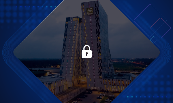 A night view of AC Hotel Amsterdam Airport with a padlock overlay on a blue background.