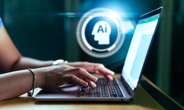 A person is typing on a laptop with an AI logo in the background.