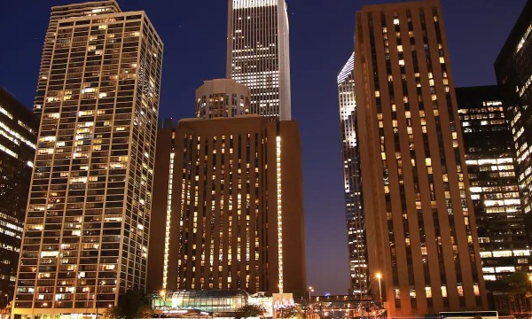 A cityscape at night with illuminated buildings, showcasing modern architecture and urban ambiance.