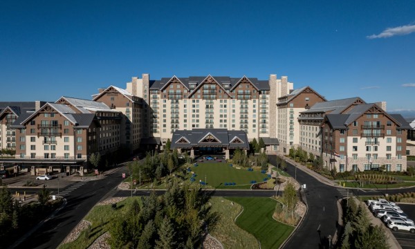 Gaylord Rockies Resort & Convention Center with architecture, landscaping, and a vibrant ambiance under a clear blue sky.