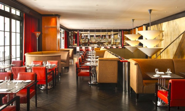 Empty interior of Lamb's Club restaurant with tables, chairs, and bar counter during the day.